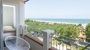 A balcony with a white chair, a view of the sea, and a beach in the background. - Hotel Atlantic Riviera (Misano Adriatico)
