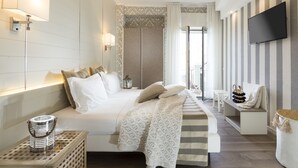 A modern hotel room with a large bed, a TV mounted on the wall, and a view of the outdoors. - Hotel Atlantic Riviera (Misano Adriatico)