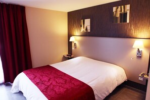 A hotel room with a large bed, two bedside lamps, a mirror, and a red curtain. - Hôtel Le Coudon (La Farlede)