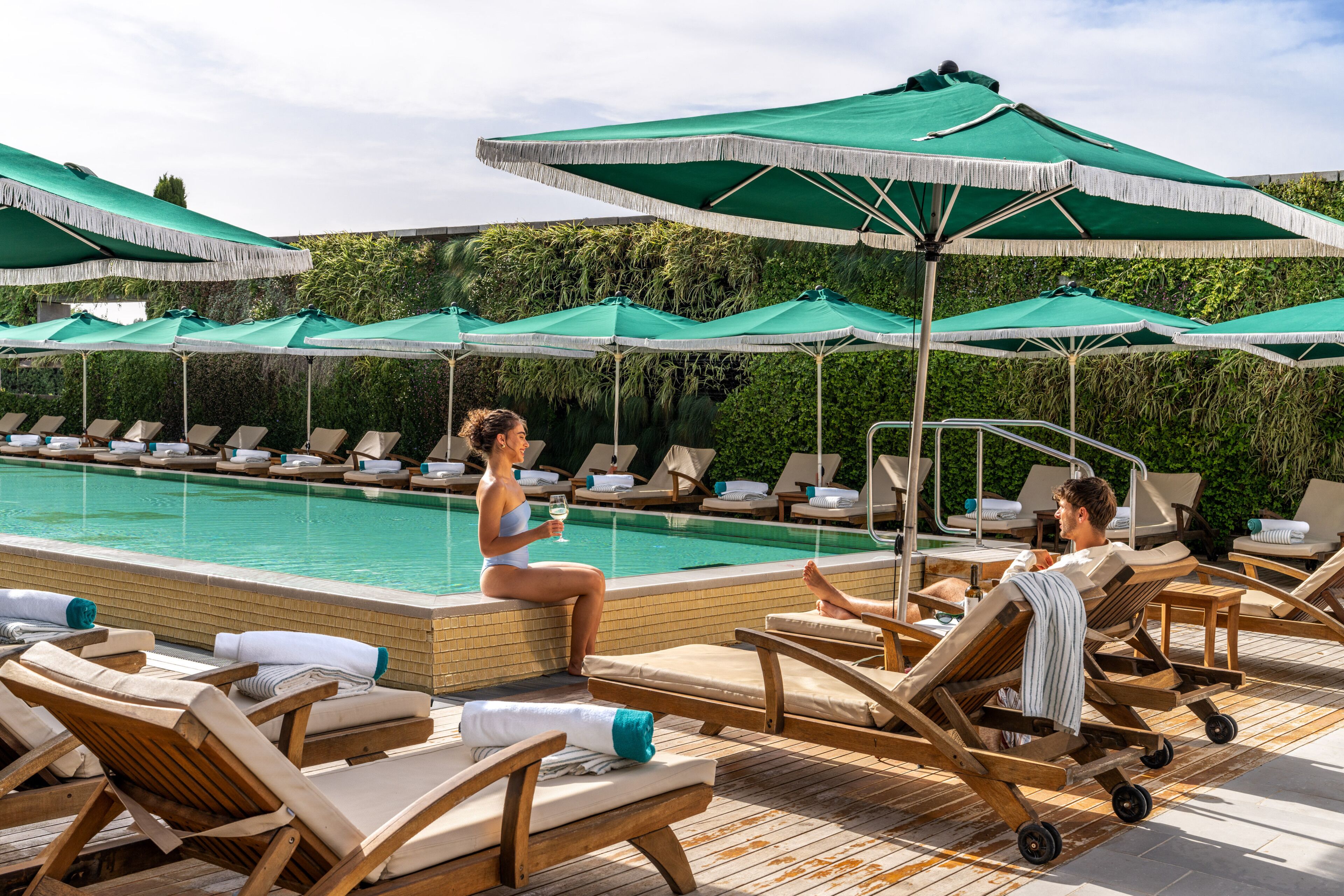 Un espace aménagé au bord de la piscine, avec des chaises longues et des parasols.