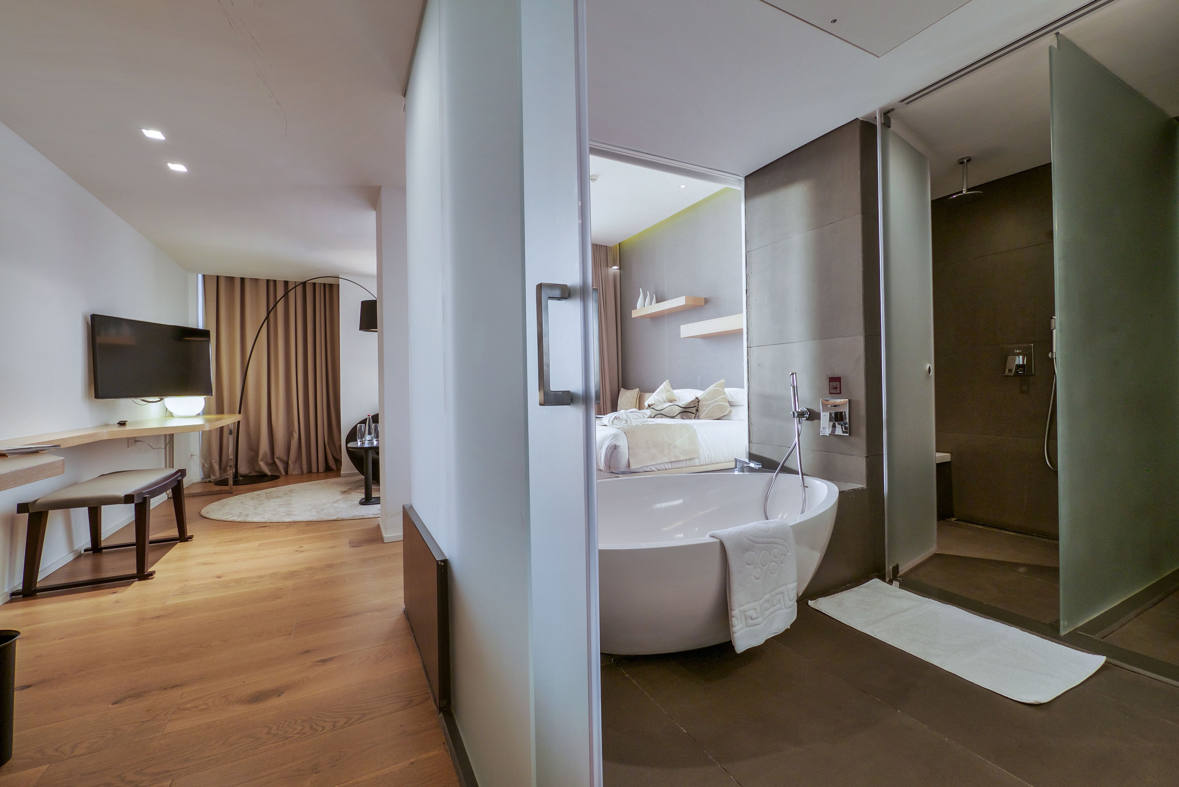 Un baño moderno con una bañera independiente, zona de ducha y tocador con espejo.
