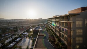 Ein modernes Hotel mit mehreren Etagen, Außenbereichen und Blick auf die umliegende Landschaft.