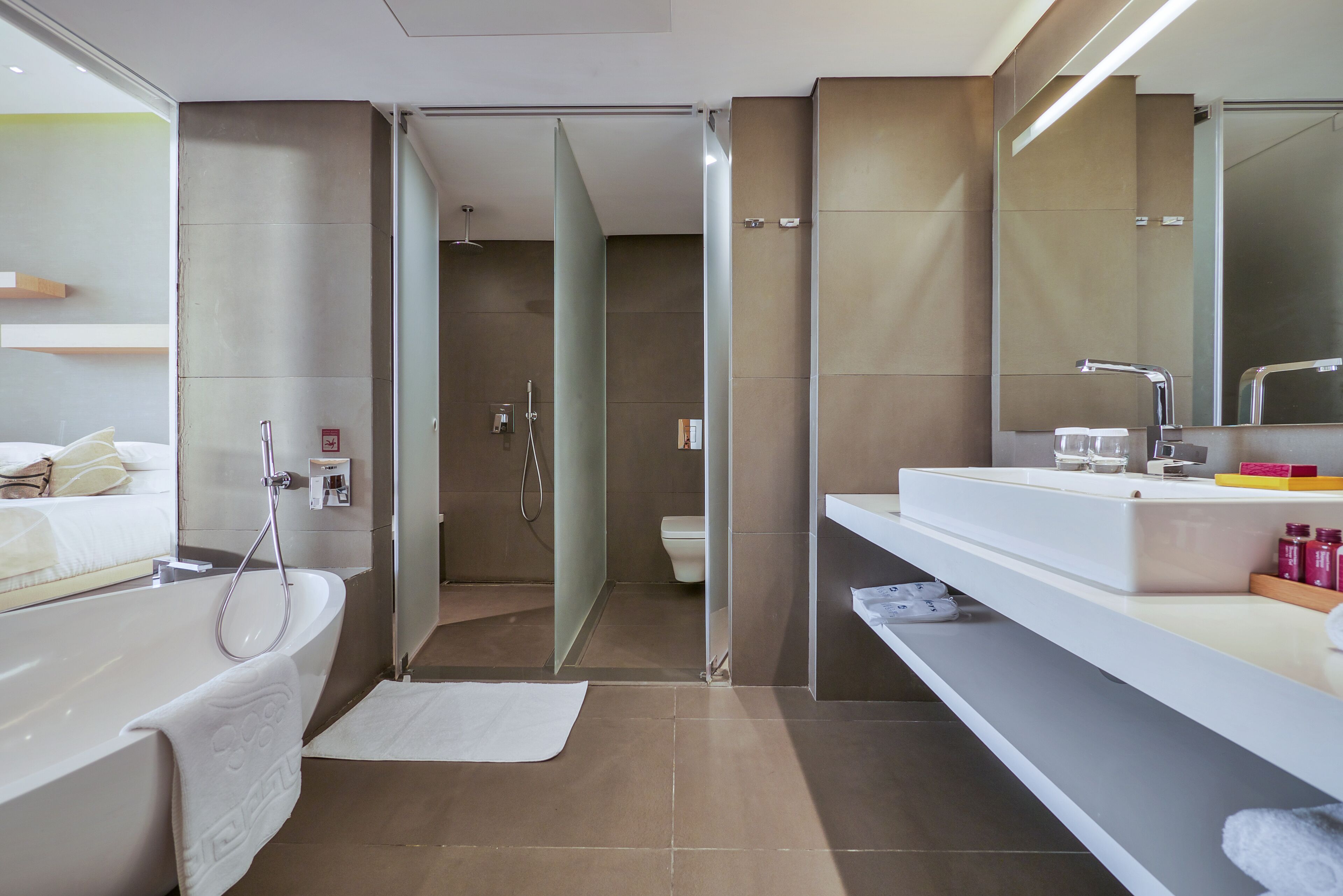 A modern bathroom with a bathtub, shower, and toilet.