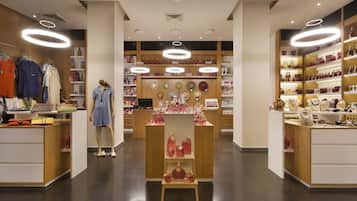 En modern butik med hyllor i trä, en central utställningsplats och en skyltdocka.