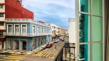 Vista de una calle con edificios, un paso de peatones y automóviles estacionados.