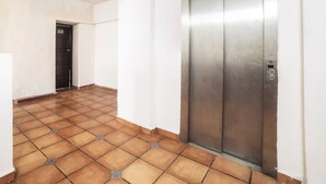 A hallway with a tiled floor, a closed elevator, and a door marked with the number 103. - Hotel Trianon (Veracruz)