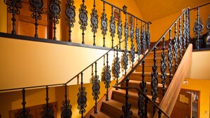 A staircase with ornate black railings and wooden steps.