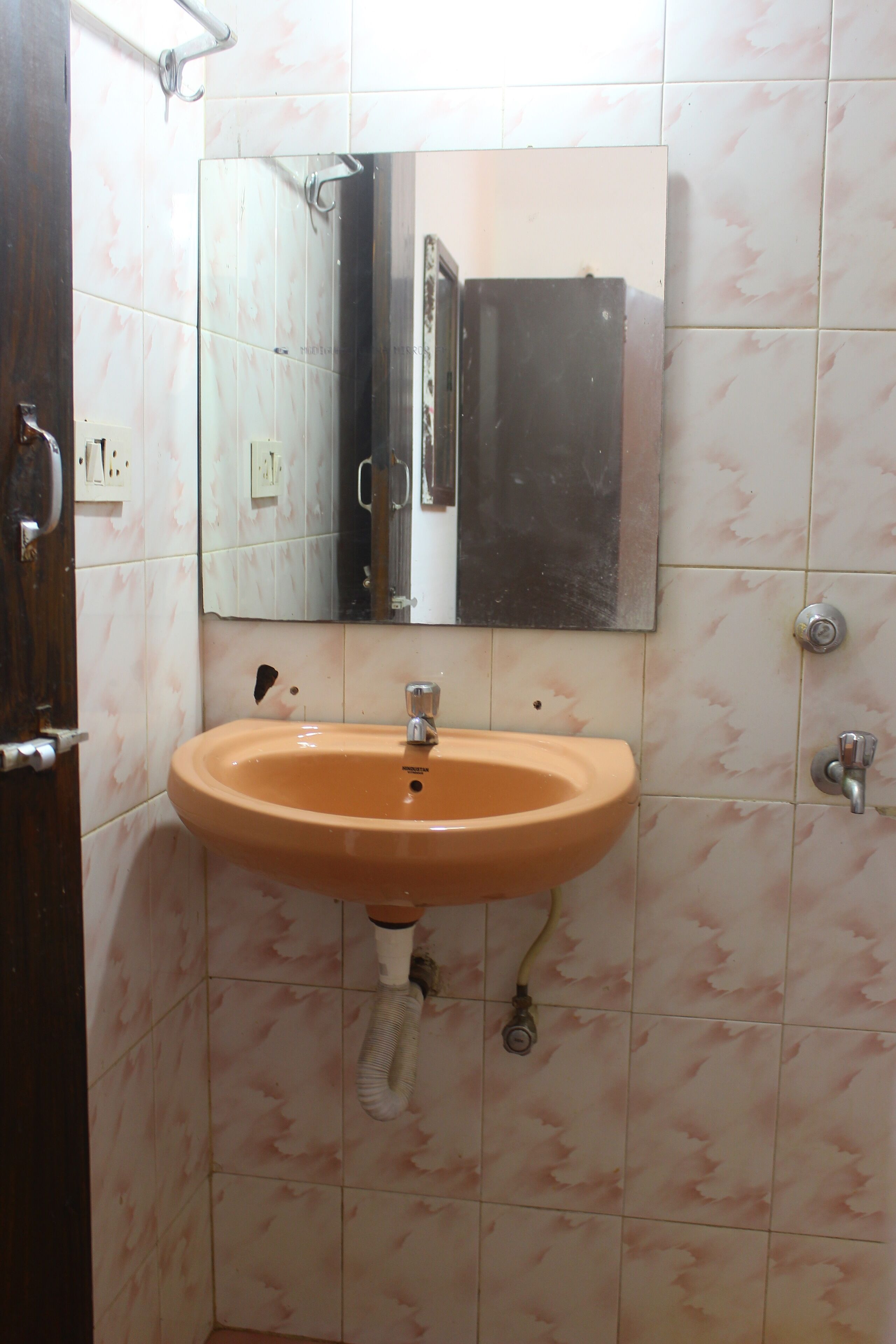 Une salle de bain avec un lavabo, un miroir et des murs carrelés.