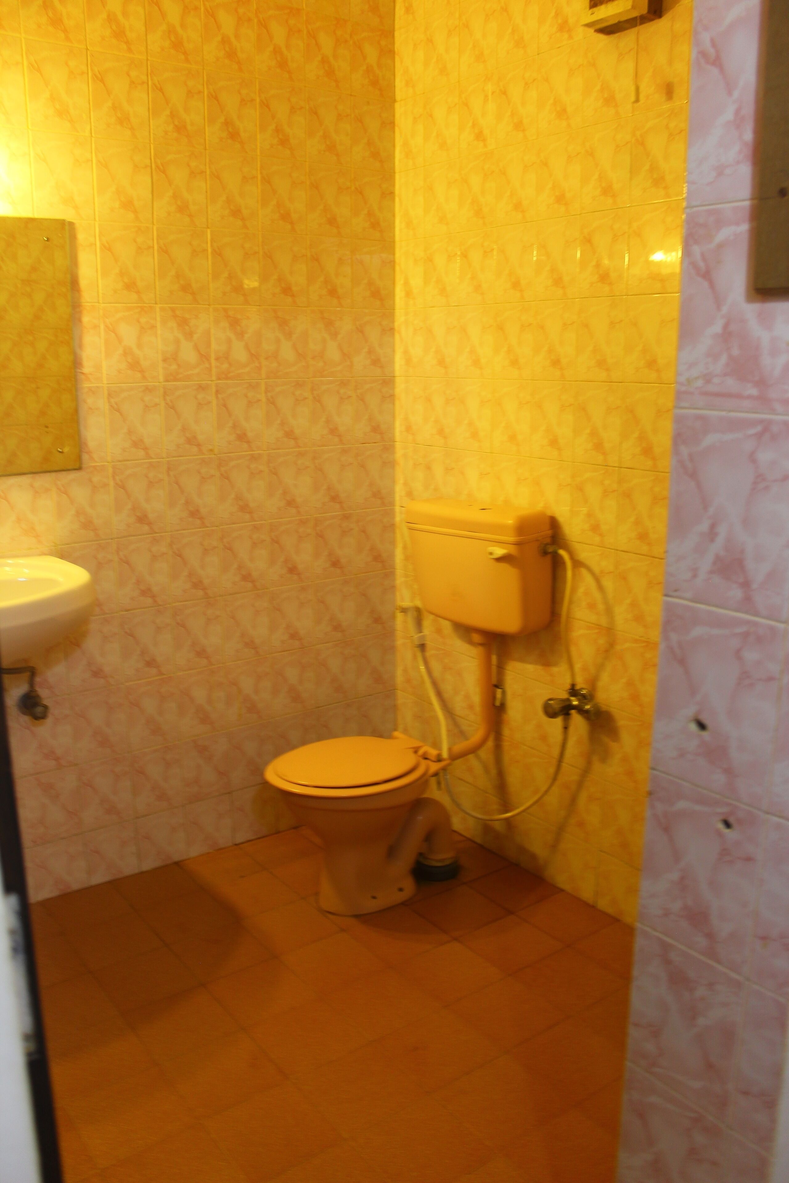 A small bathroom with a toilet, sink, and tiled walls.