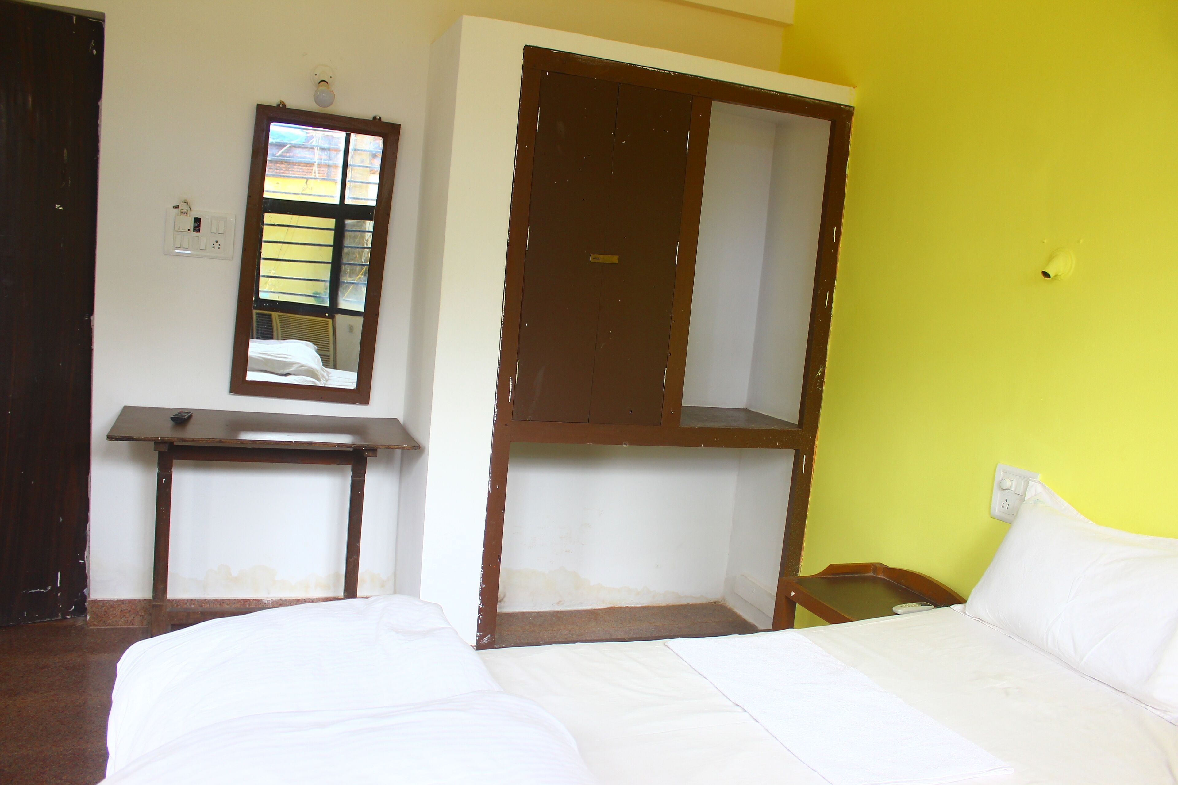 A room with a bed, a desk, and a mirror.