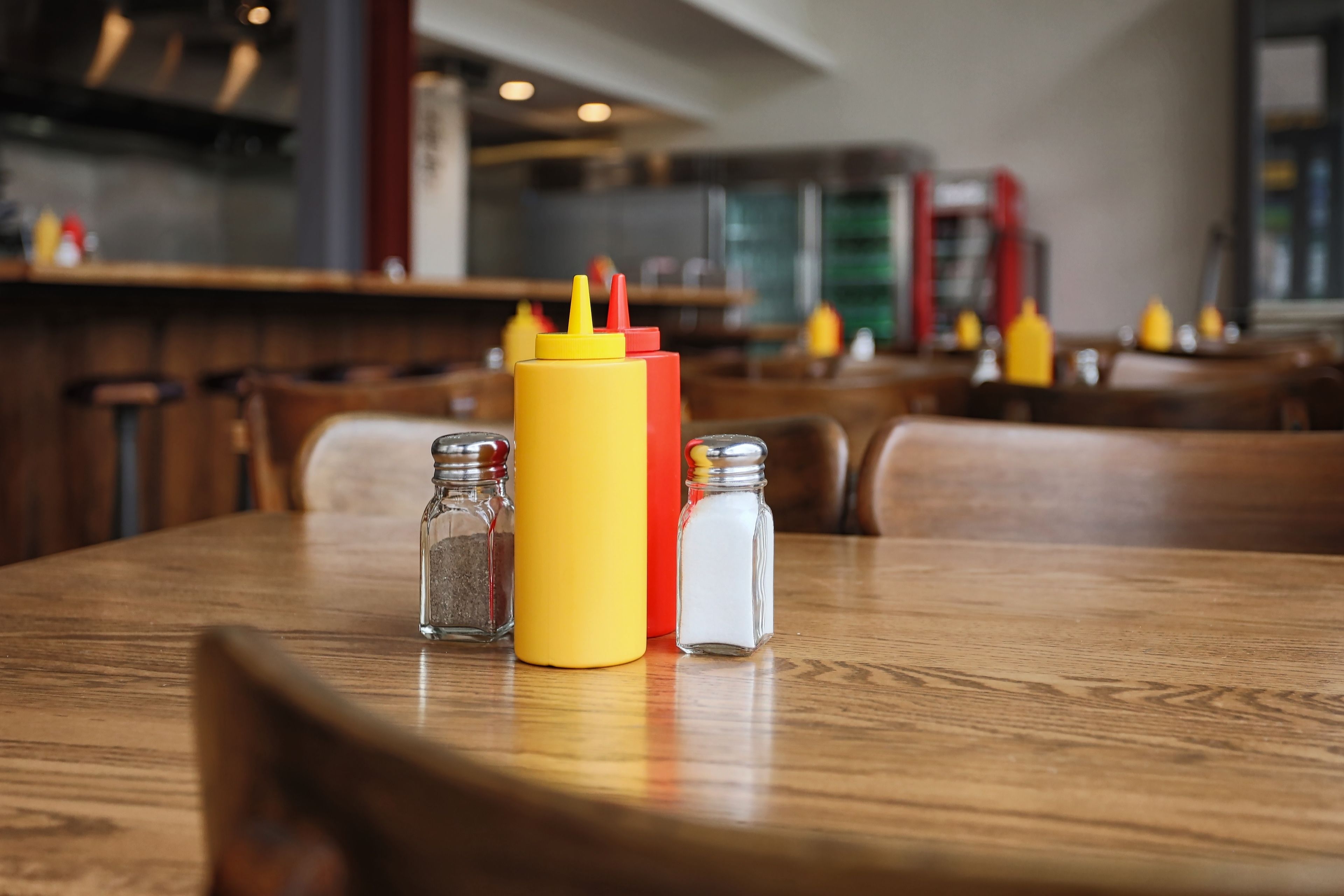 Una mesa con condimentos y saleros en un restaurante.