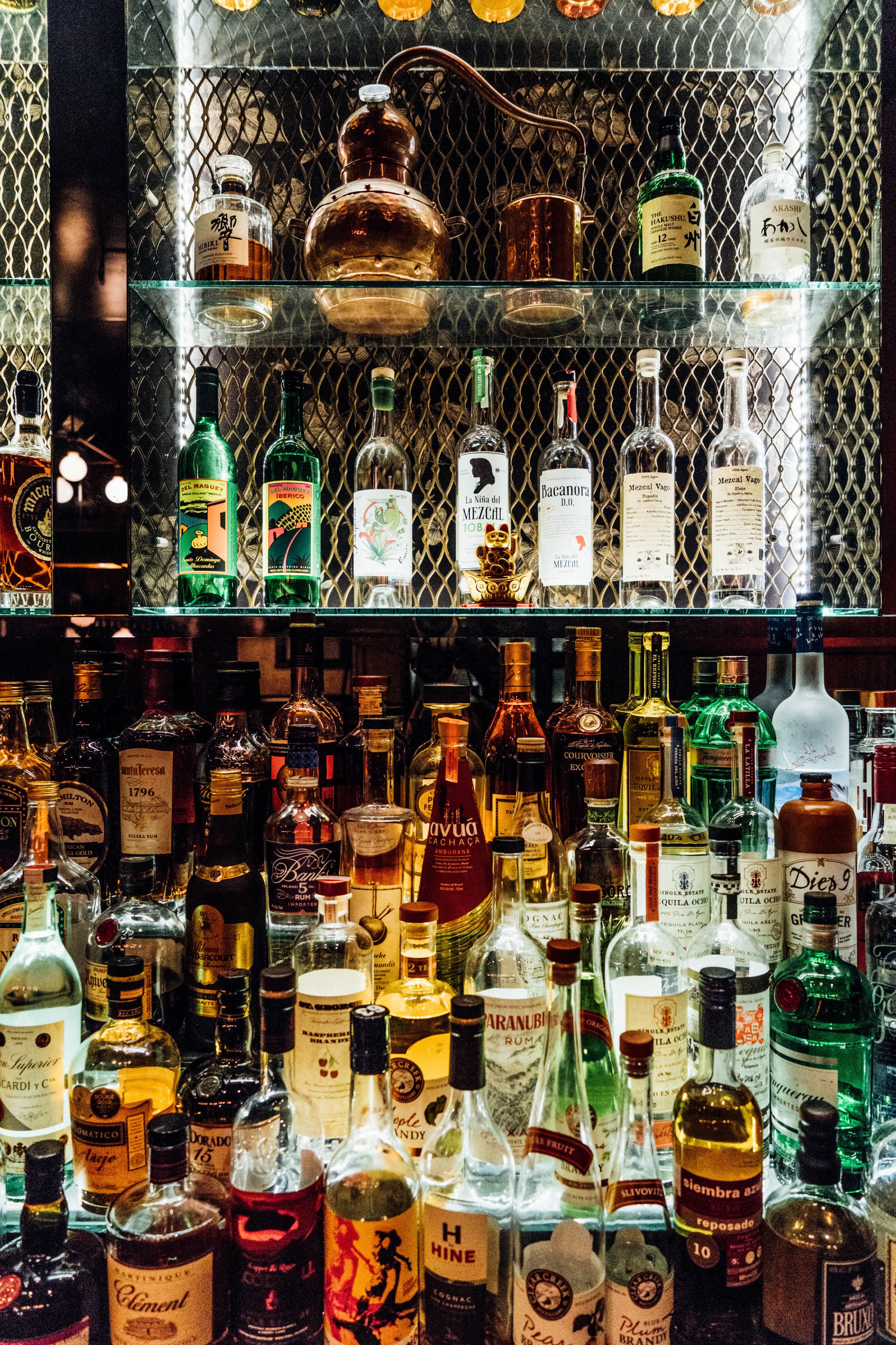 A bar with various bottles of liquor on shelves.
