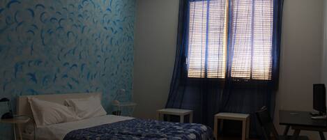 Un dormitorio con cama, escritorio y silla.