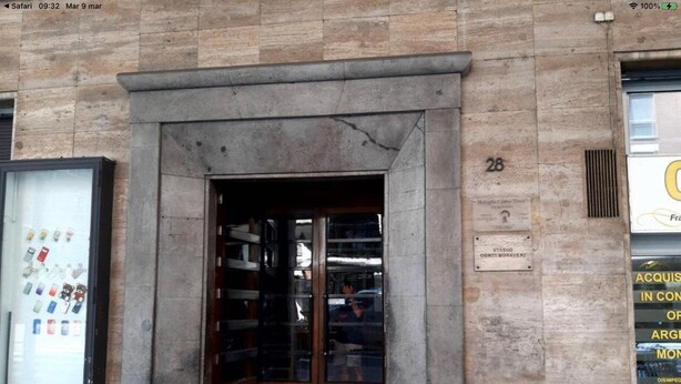 A building entrance with a stone facade, a glass door, and a red carpet leading inside. - Bologna Center Town (Bologna)