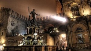 A historic building with a prominent statue in the center, arched windows, and a stone facade. - Bologna Center Town (Bologna)