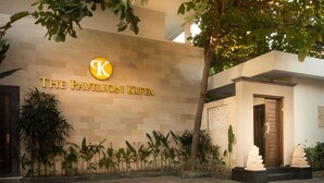 Fachada de un edificio con un letrero que dice "The Pavilion Kota" y un logotipo.
