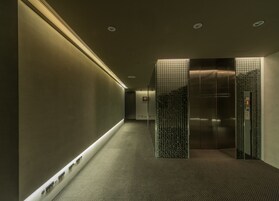 Een moderne lift met een metalen afwerking en een glazen paneel.