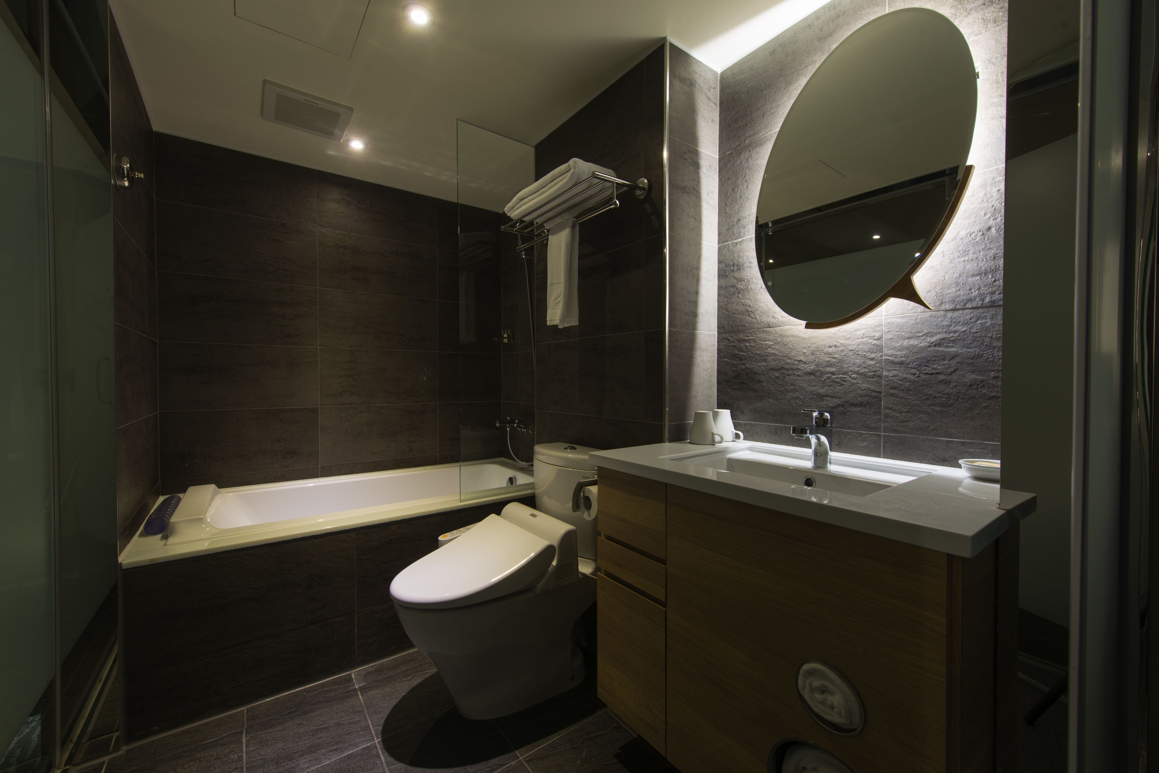 Un baño moderno con bañera, inodoro y tocador.