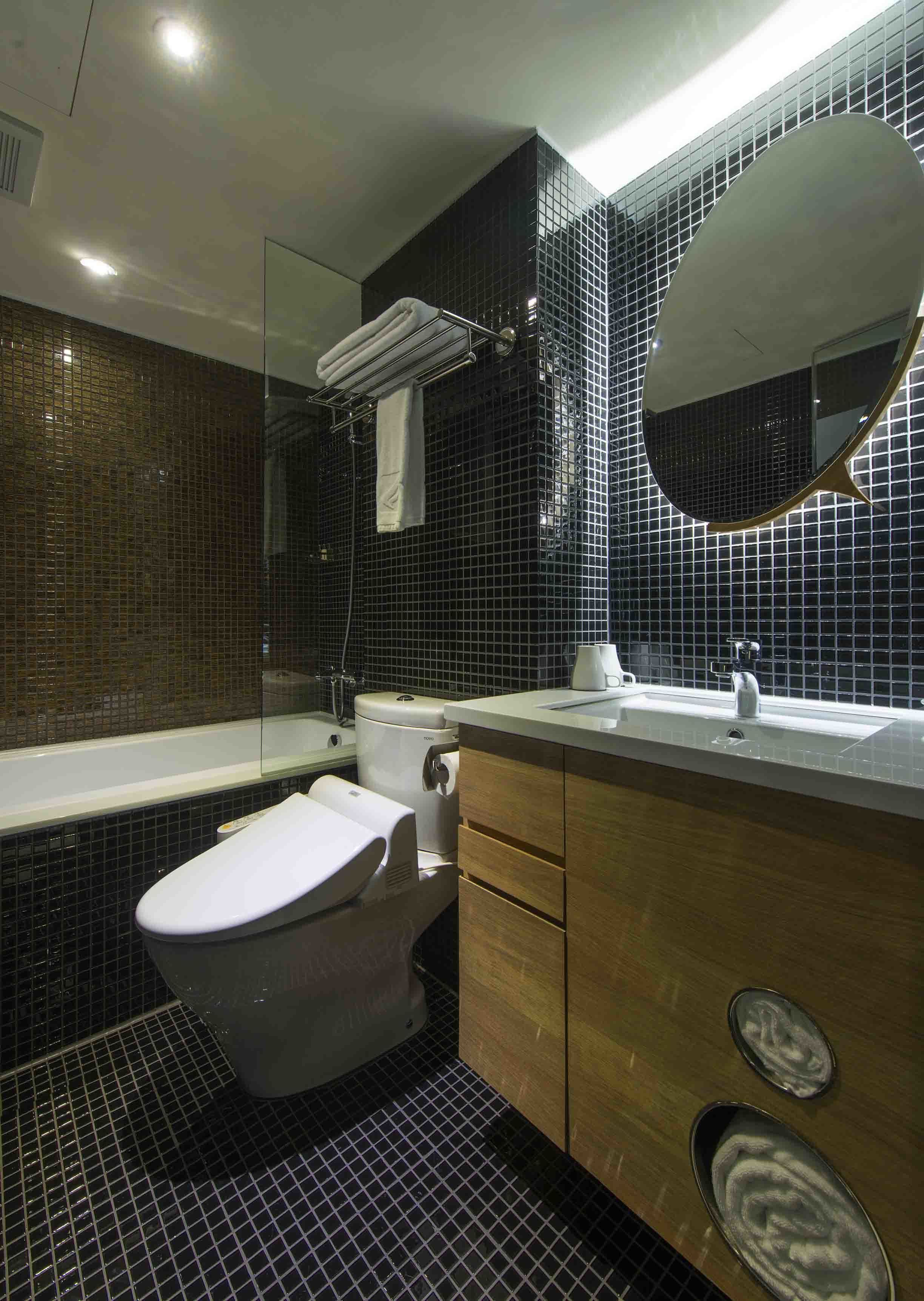 Une salle de bain moderne avec des toilettes, un lavabo et un miroir.