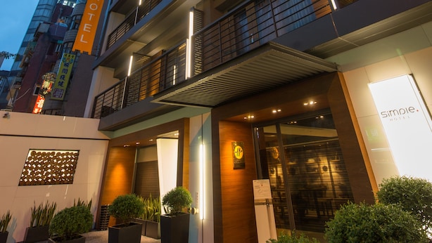 A modern hotel with a multi-story structure, a well-lit entrance, and a visible reception area. - Simple Plus Hotel (Taipei)