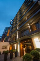Een modern hotel met een meerlaags gebouw, een goed verlichte ingang en een zichtbare receptie.