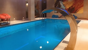An indoor swimming pool with clear blue water, surrounded by beige walls and a modern design. - Hotel La Siesta (Wladyslawowo)