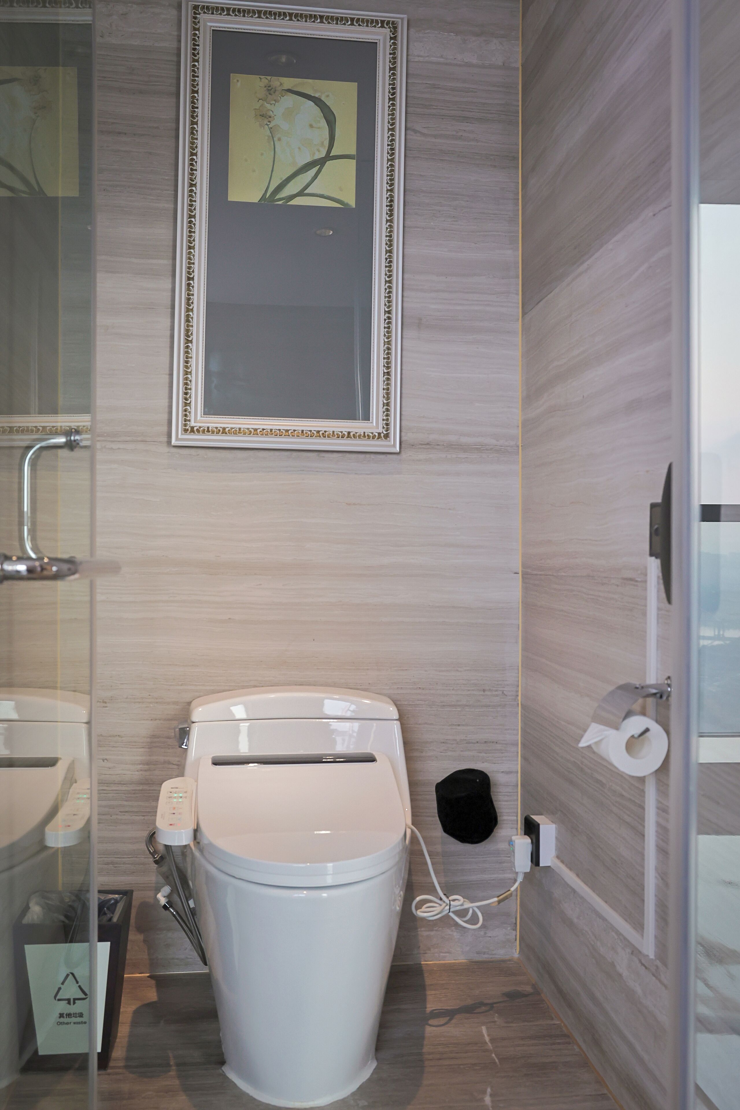 A modern bathroom with a toilet, a sink, and a shower area.