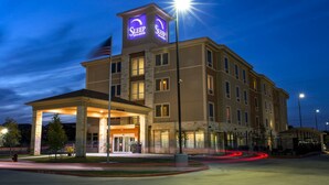 A hotel with a prominent sign reading "Sleep Inn & Suites" and a well-lit entrance. - Sleep Inn & Suites Austin Northeast (Austin)