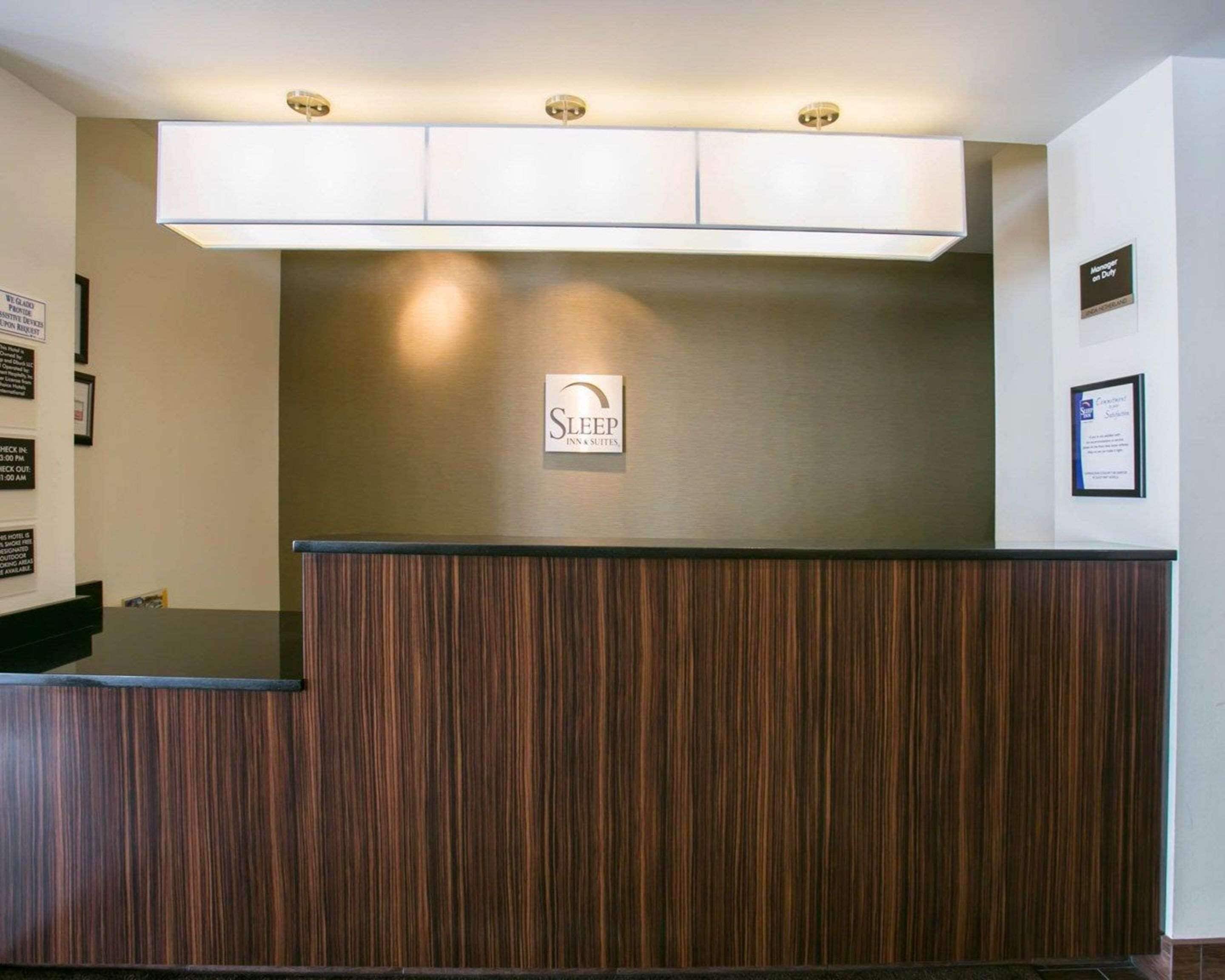 Un comptoir d’accueil avec une enseigne indiquant « Sleep Inn & Suites ».