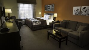 A hotel room with a bed, a desk, a couch, and a coffee table. - Sleep Inn & Suites Austin Northeast (Austin)