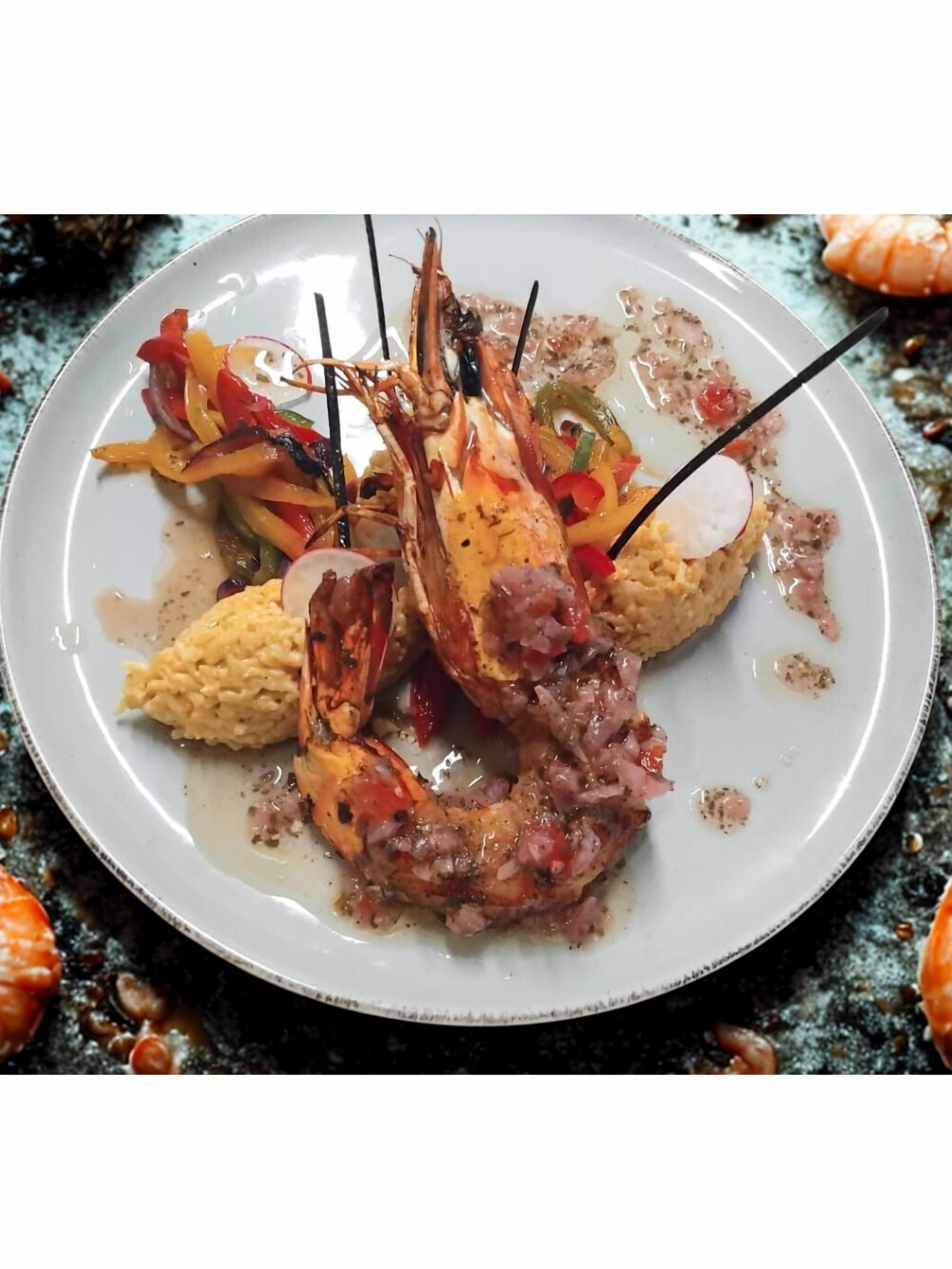 Un plato con camarones a la parrilla, arroz y verduras.