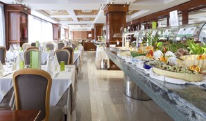 A hotel dining area with multiple tables set for guests, a buffet with a variety of food items, and a clean, well-lit interior. - Hotel ValleMar (Puerto de la Cruz)
