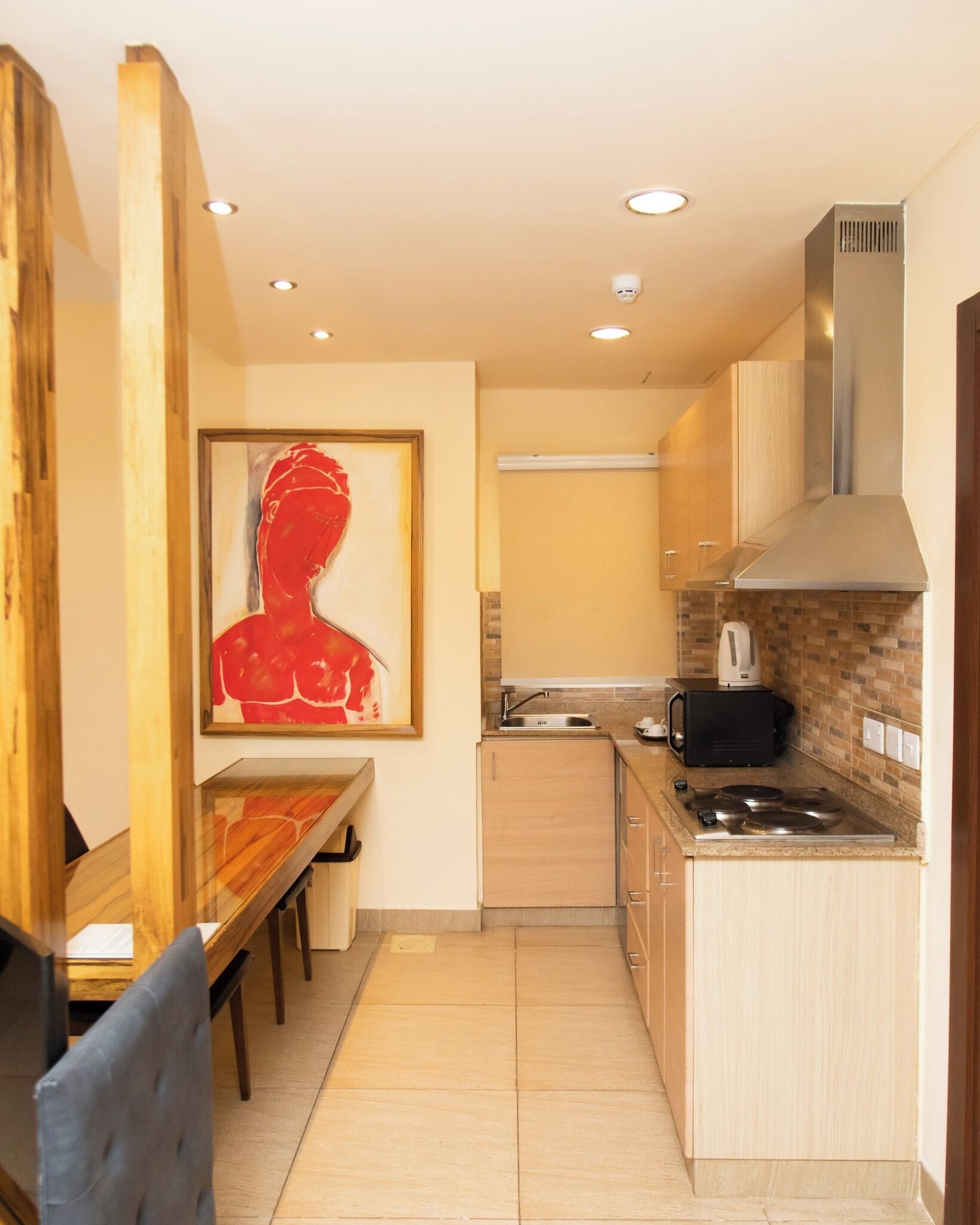 A compact kitchen with a dining area, a stove, a microwave, and a sink.