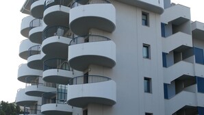 A multi-story hotel with balconies, a sign for 'Atlantic Hotel', and a white van parked in front. - Apart Hotel Atlantic (Grado)