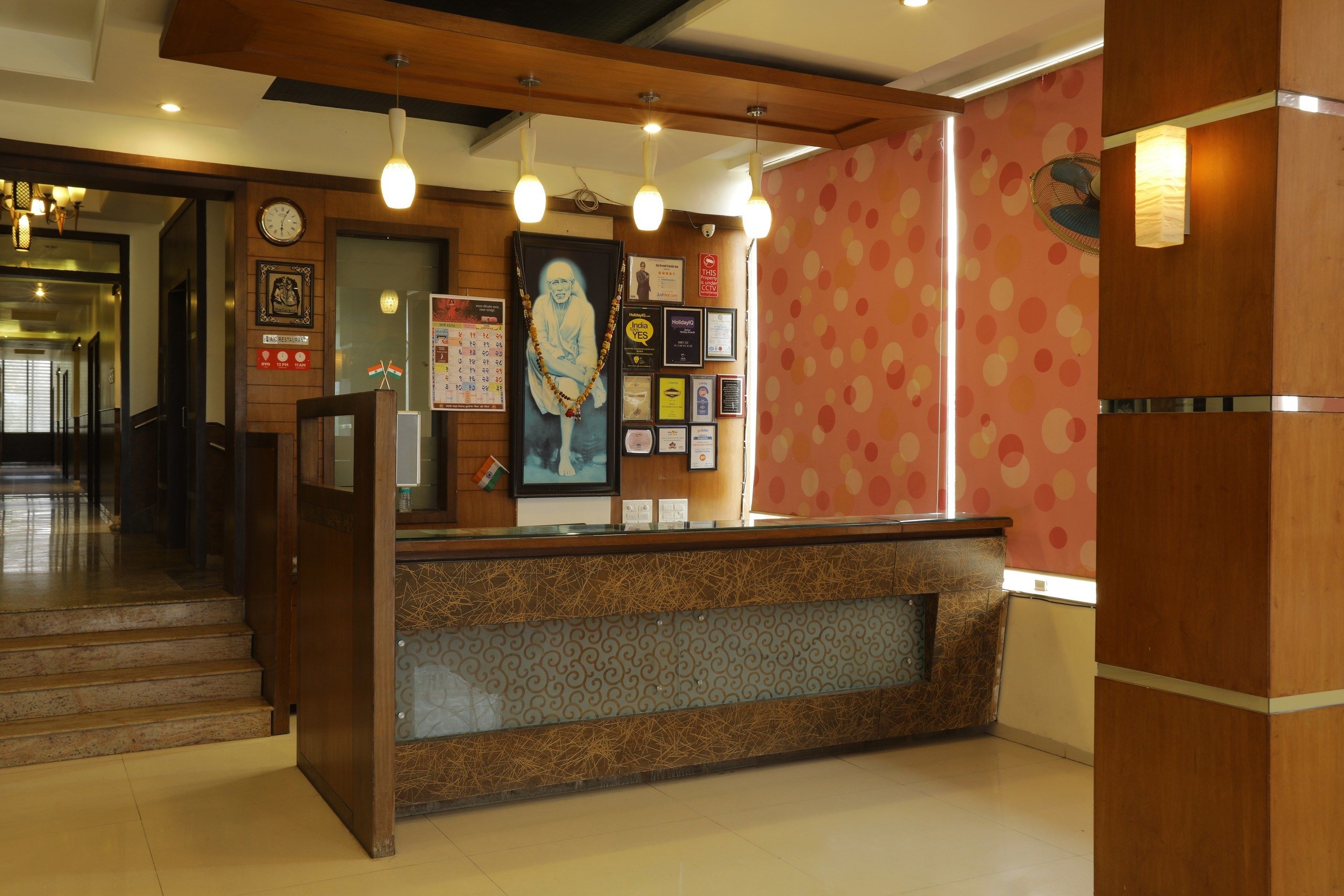 A reception area with a wooden counter, framed pictures, and a clock on the wall.