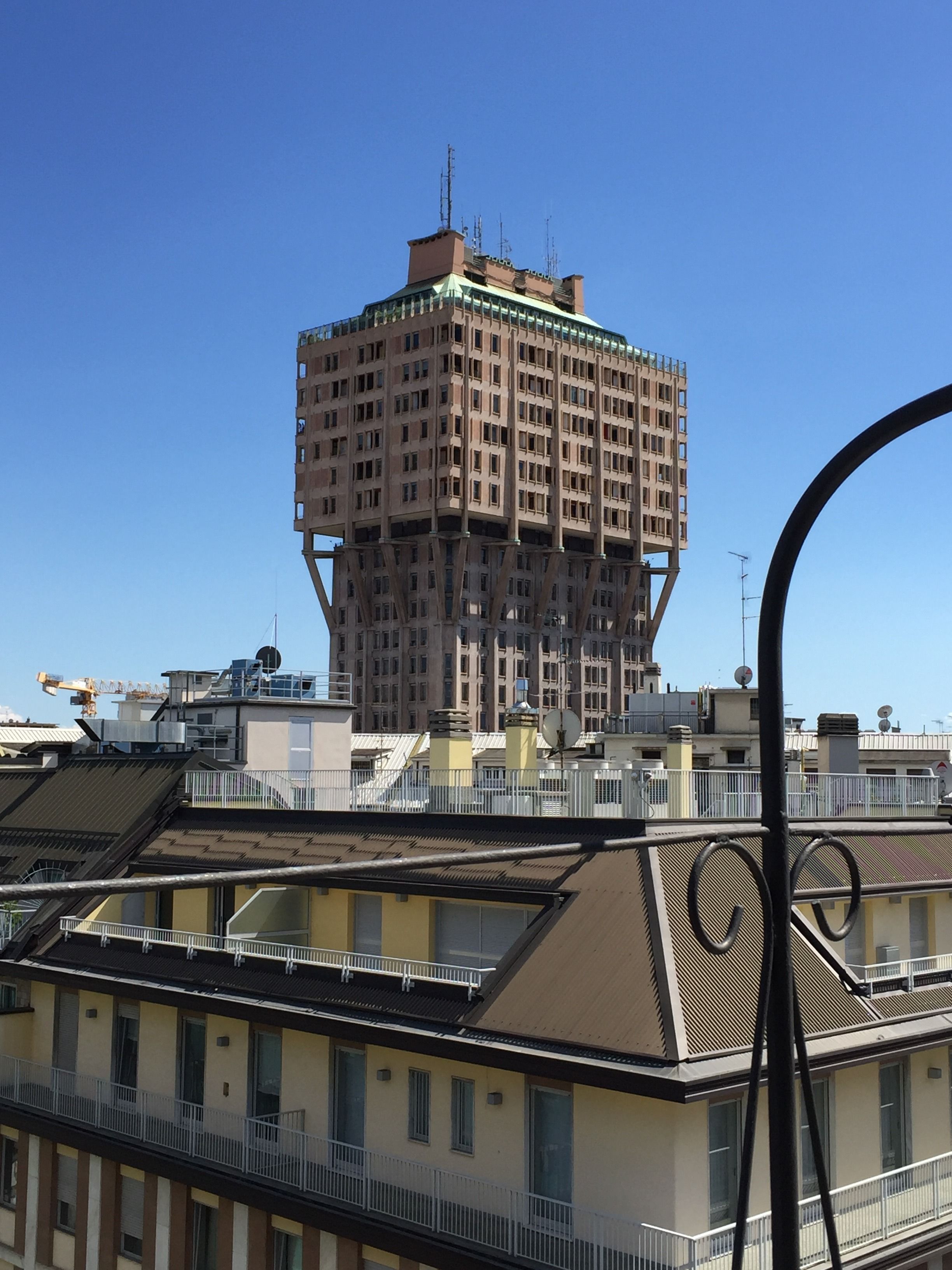 Un edificio de varios pisos con un diseño arquitectónico distintivo, que presenta un núcleo central y balcones circundantes.