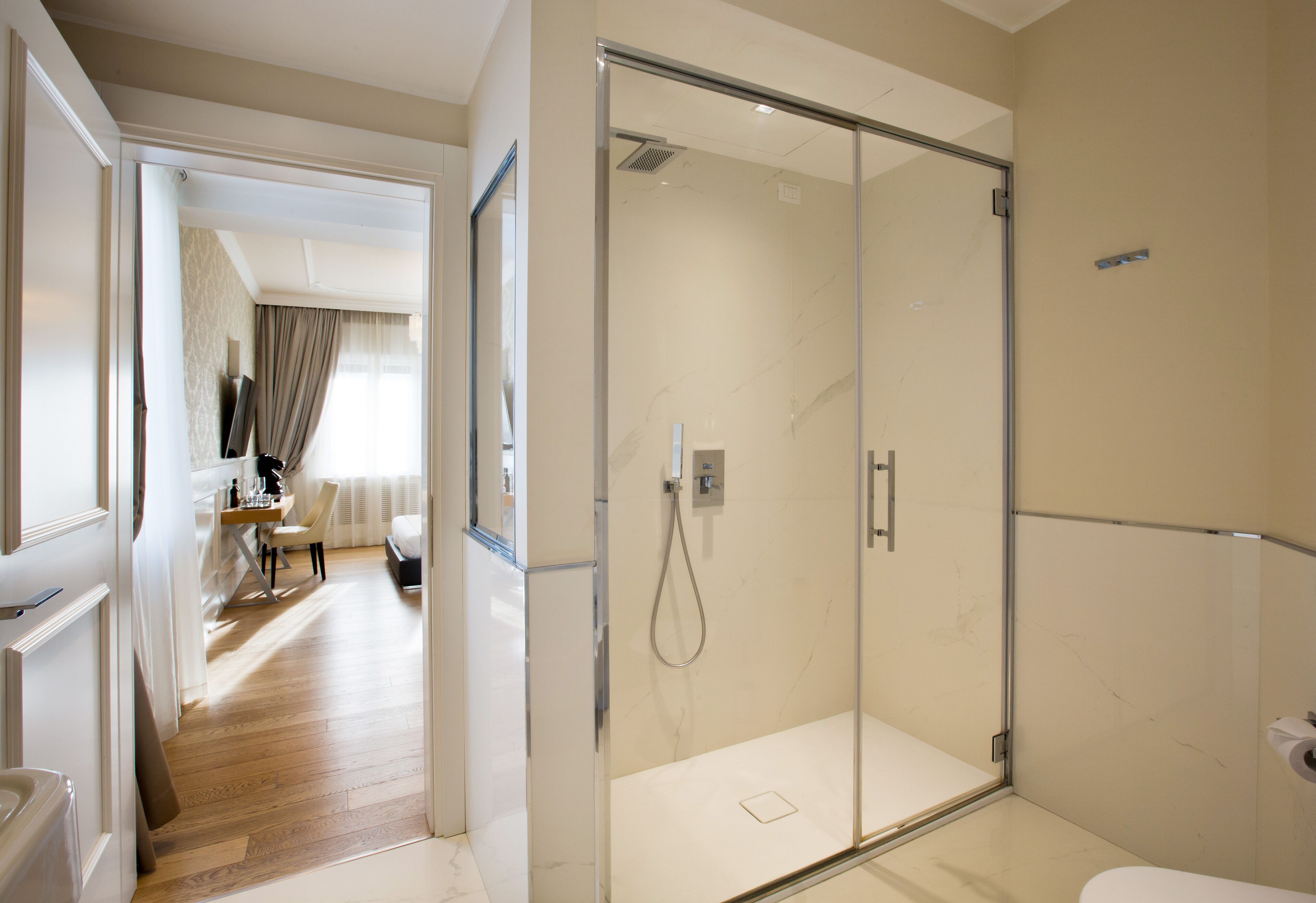 A modern bathroom with a glass shower enclosure, a toilet, and a visible shower control panel.