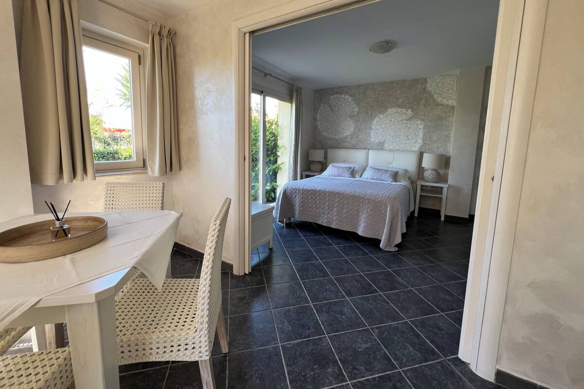 A hotel room with a bed, a desk, and a chair.