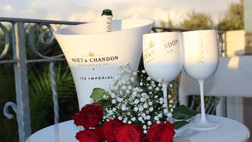 A table with two Moët & Chandon champagne glasses, a large bottle, and red roses.