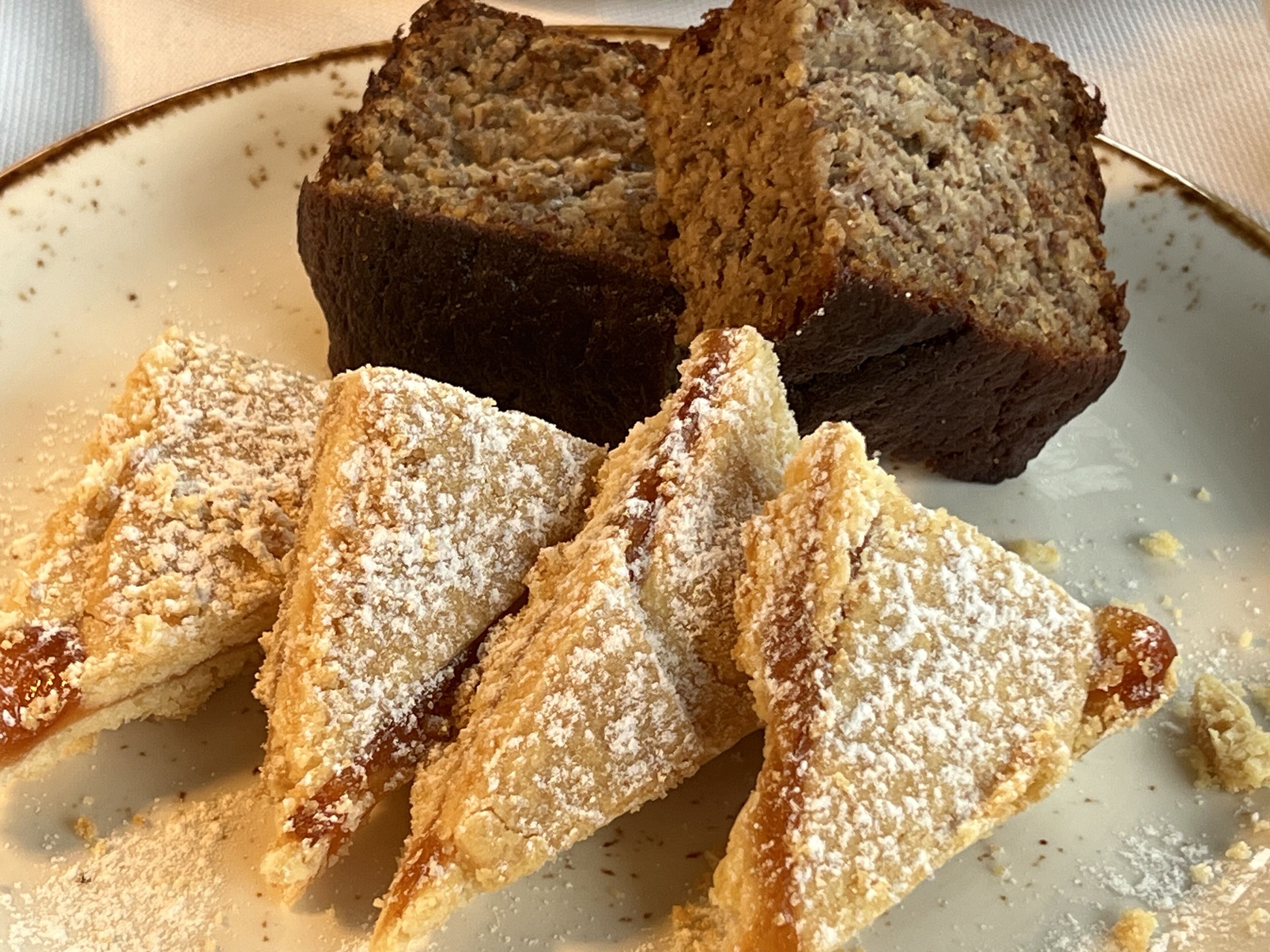 A loaf of bread and triangular pastries on a plate.