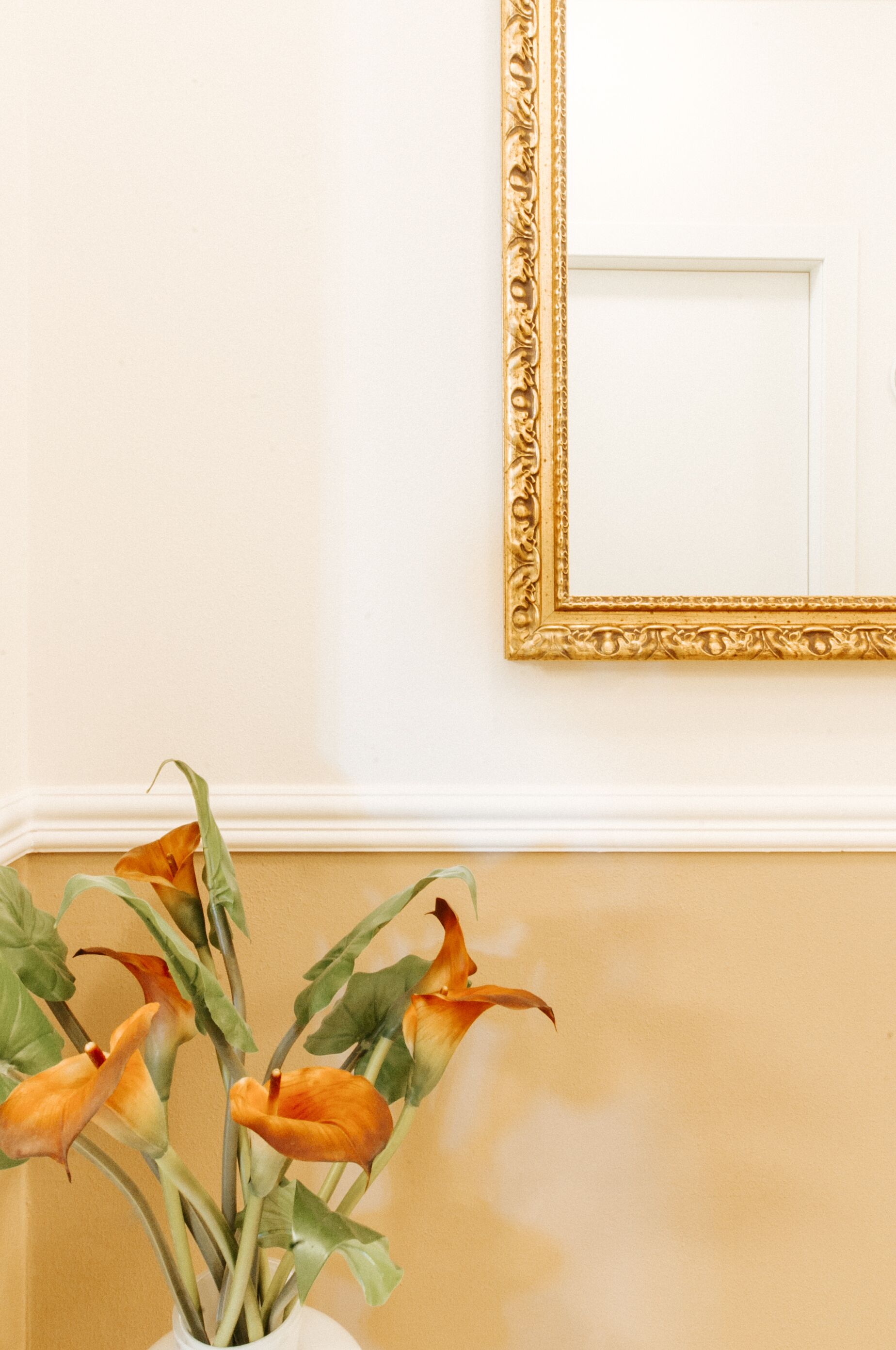 A vase with flowers on a wall.