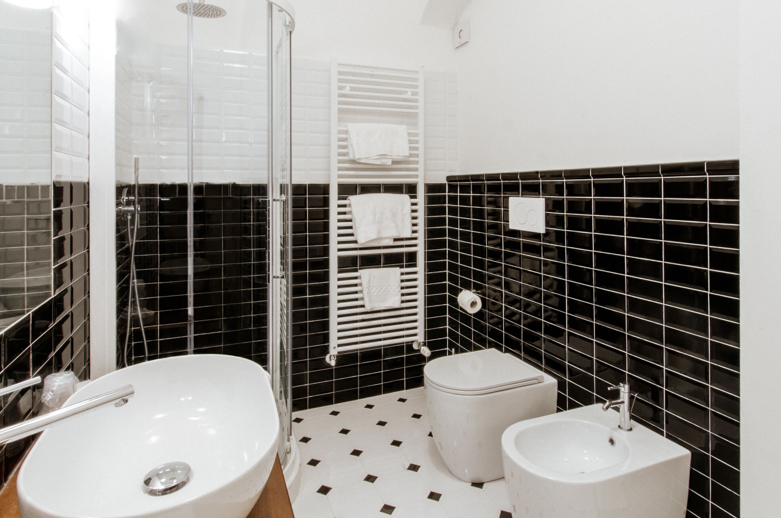 Un baño con un lavamanos blanco, un inodoro y una ducha con mampara de vidrio.