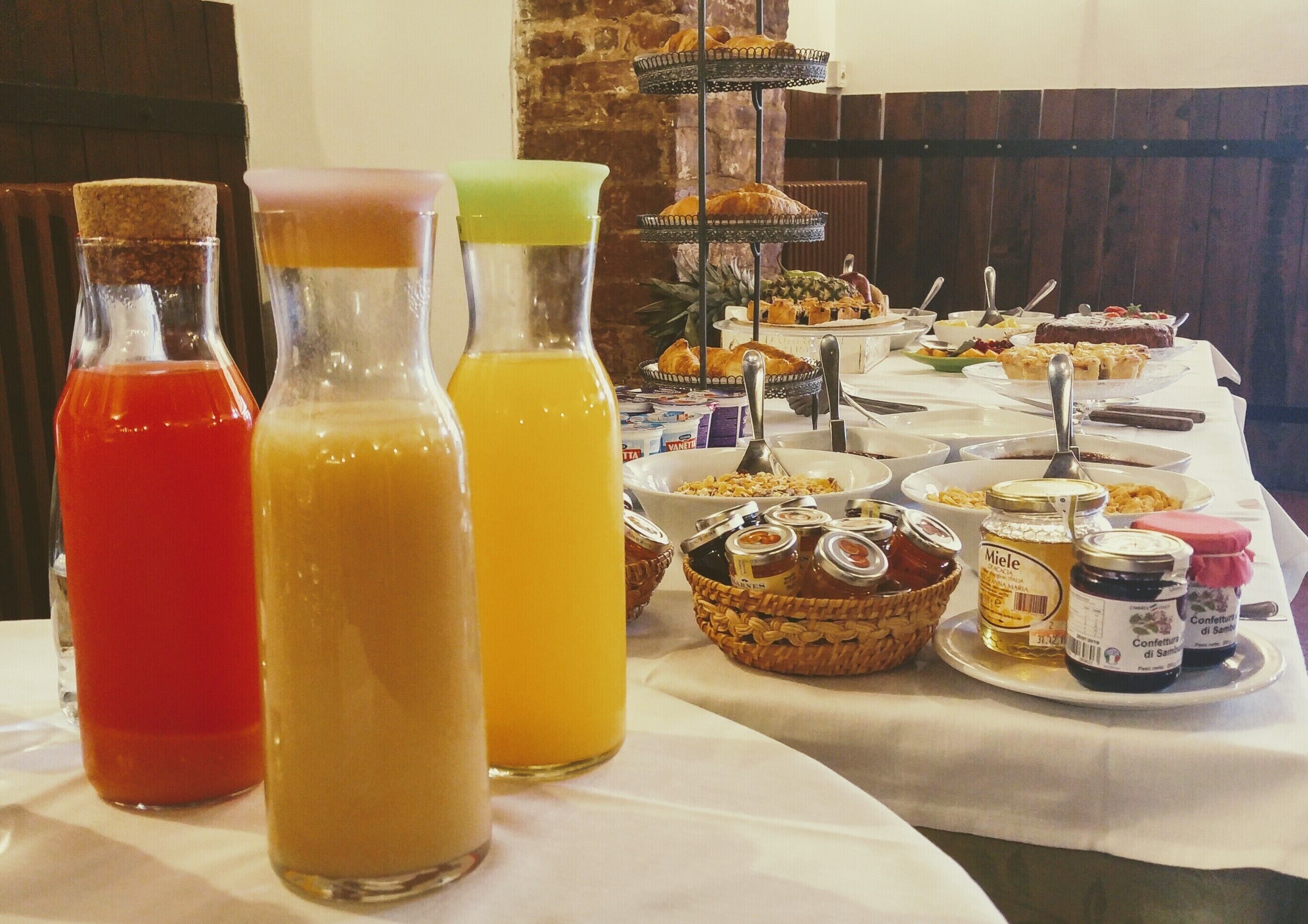 Uma mesa de buffet com diversos alimentos, incluindo frutas, doces e acompanhamentos.