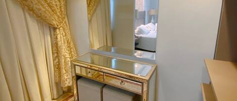 A bathroom with a vanity, a mirror, and a patterned rug.