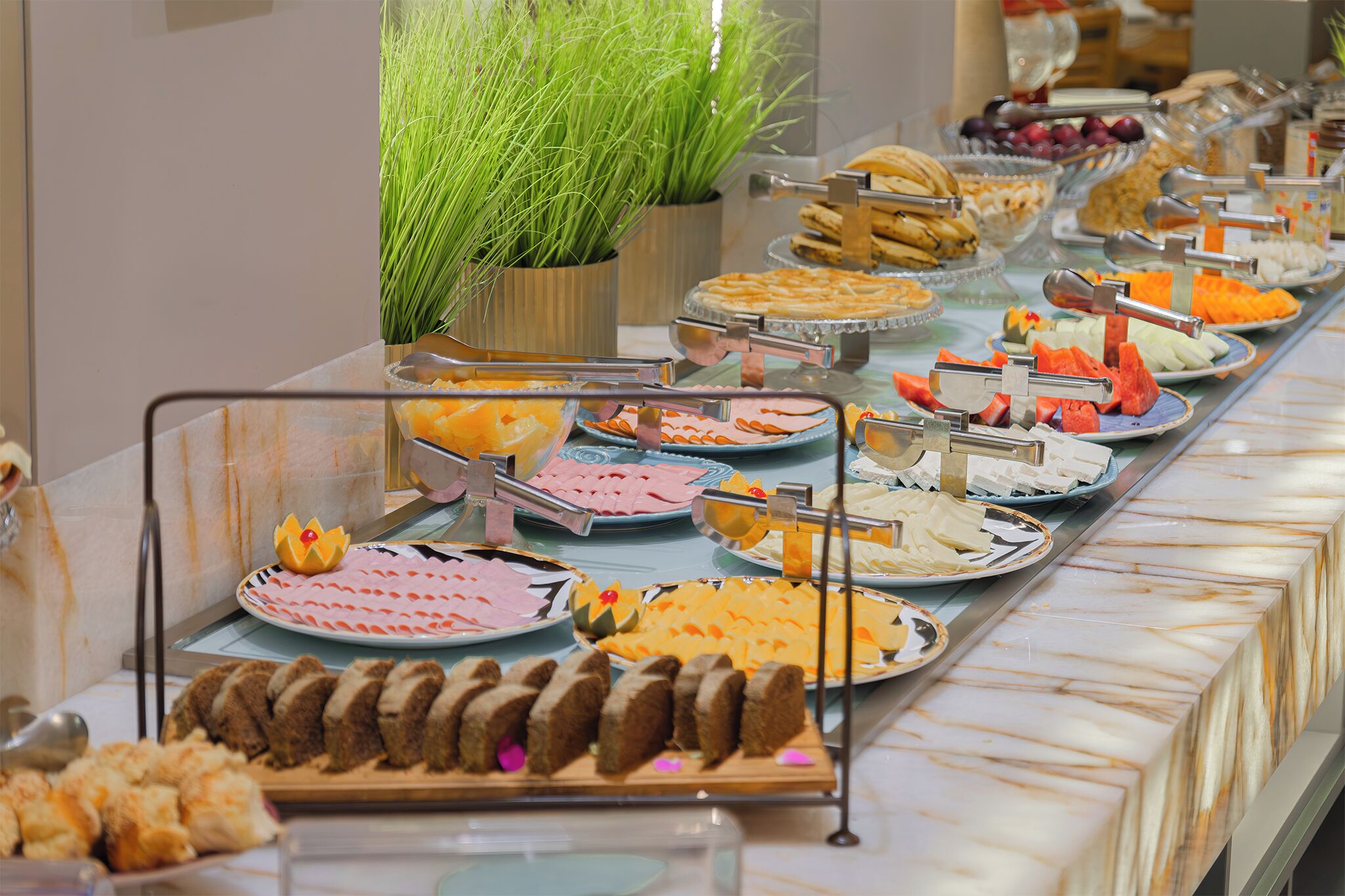 Ein Buffet mit verschiedenen Speisen und einer Topfpflanze.