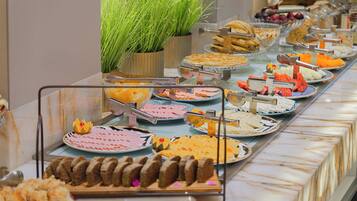 Ein Buffet mit verschiedenen Speisen und einer Topfpflanze.
