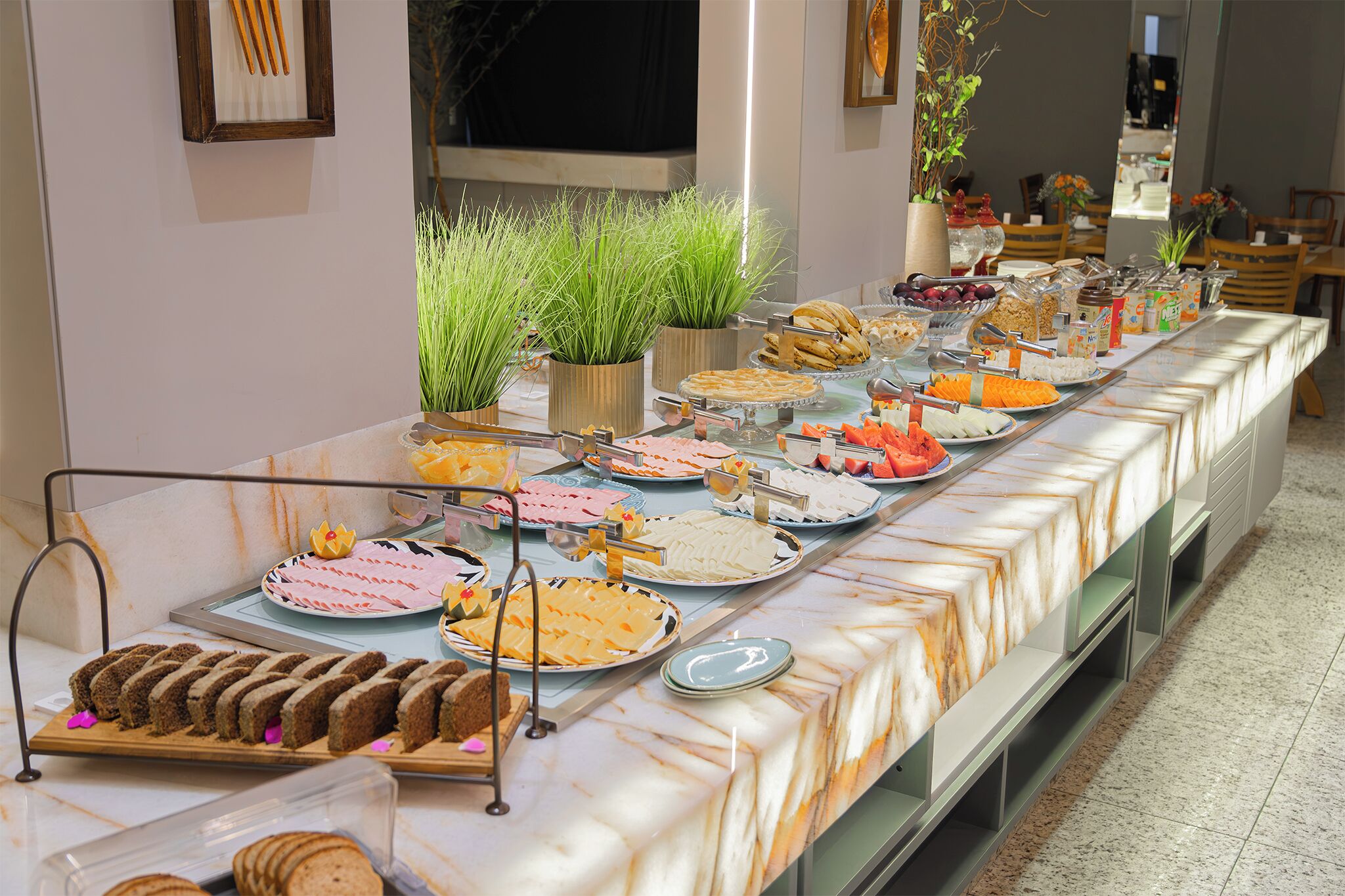 A buffet with various food items and a marble tablecloth.