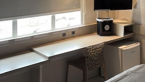A modern room with a desk, a chair, a TV, and a window. - Hotel Palmas Executivo (Balneário Camboriú)