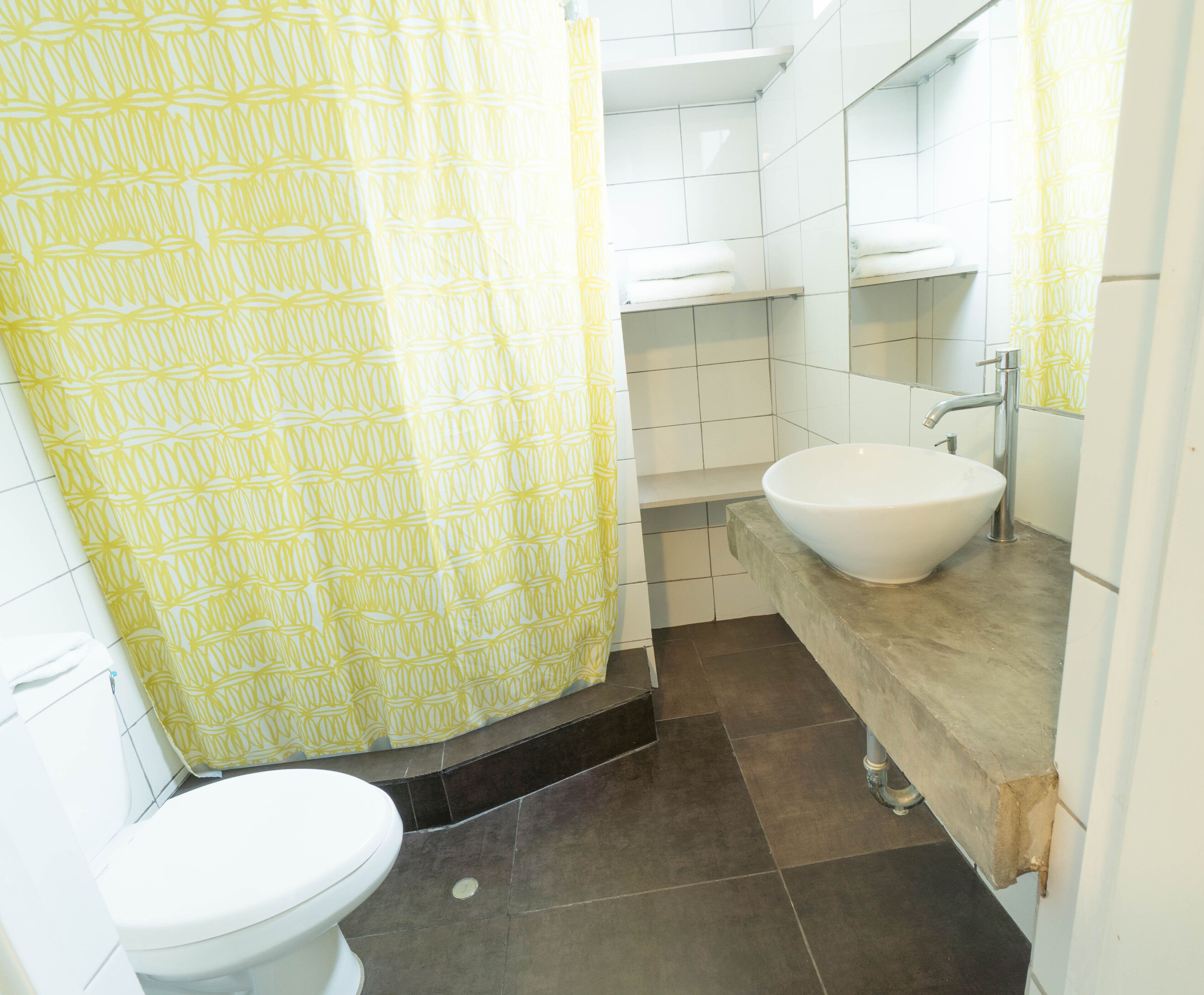 A bathroom with a toilet, a sink, and a shower curtain.