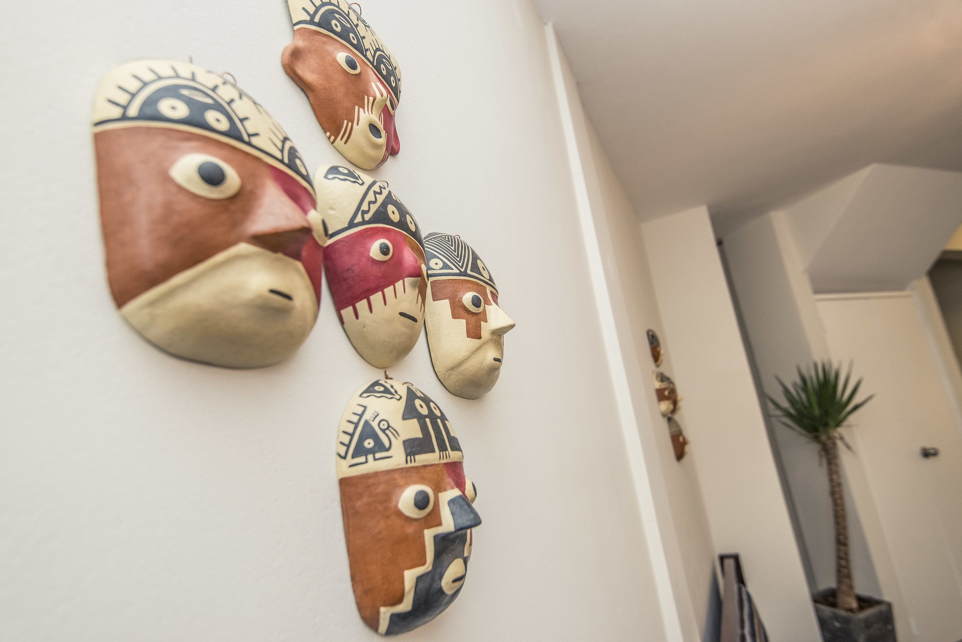 Un mur orné de plusieurs masques décoratifs.